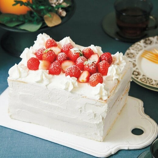 カッティングボードに置かれたイチゴのホワイトクリスマスケーキ