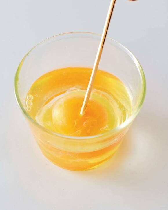 楊枝で生卵を刺す様子