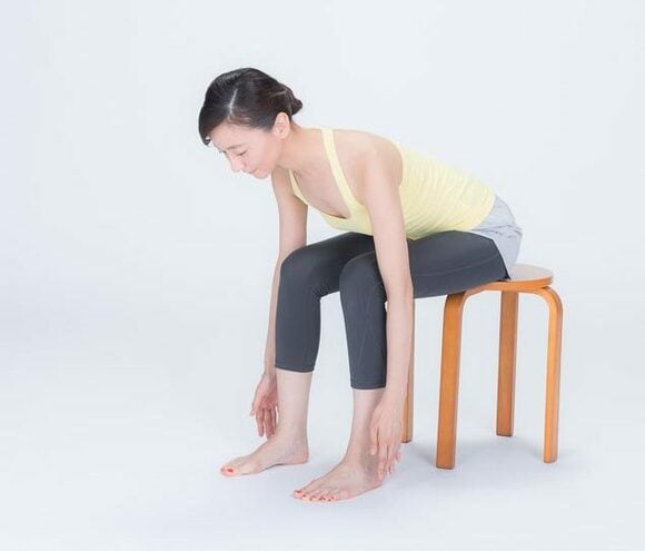 イスに座って前傾し腕を真っすぐ下ろす