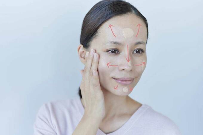 指の腹を使って顔全体に伸ばす様子