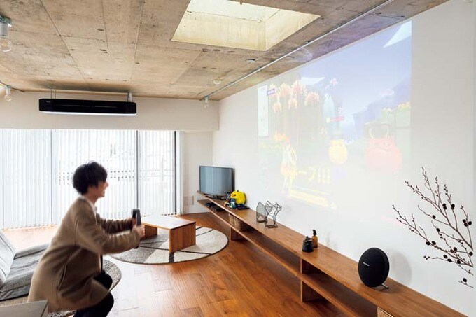 プロジェクター投影したゲームを楽しむ夫