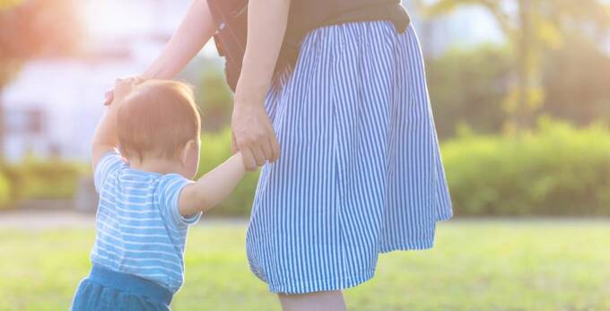赤ちゃんの手をとる女性