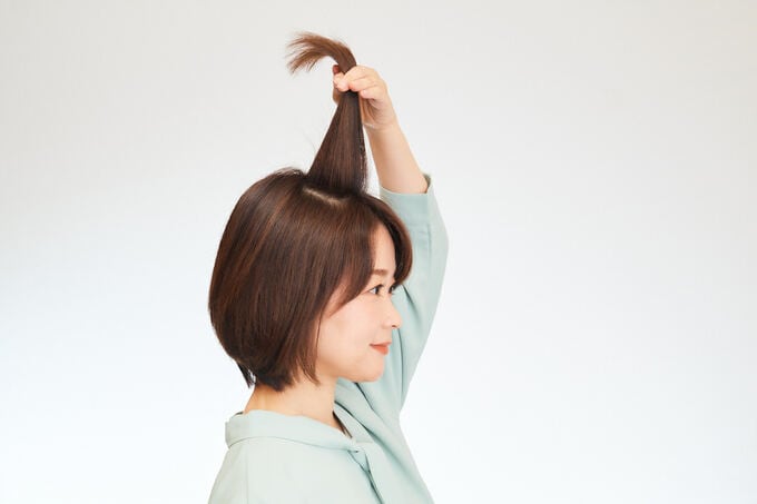 髪を持ち上げる女性