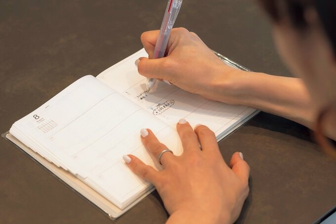 手帳にメモする様子