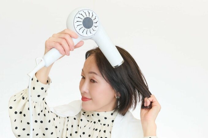 毛先にも指を差し入れて、下に引っ張るようにしながらドライヤーの風をあてる