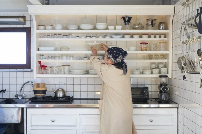 食器棚の前に女性