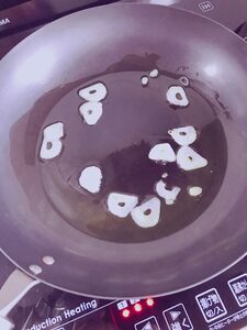 フライパンにオリーブオイルとニンニクを入れ、弱火で熱する