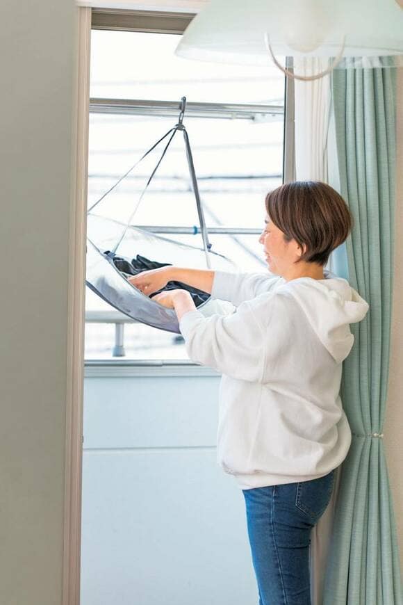 ベランダで洗濯ものを干す女性