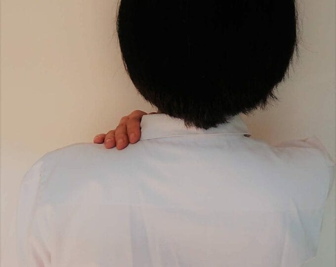 肩をおさえる様子