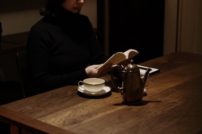 ダイニングで本を読む女性
