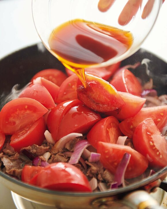 トマトと調味料を加える様子