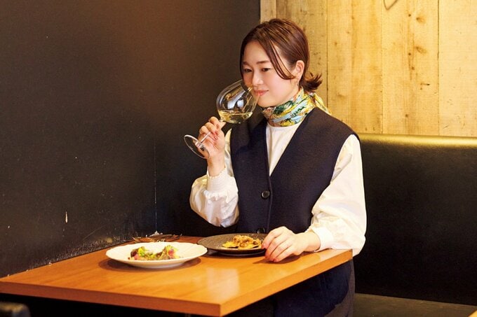 ワイングラスで白ワインを嗜む女性