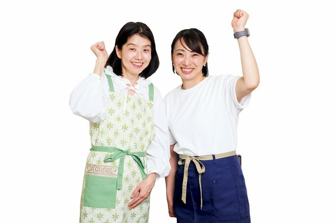 ガッツポーズをするエプロン姿の女性二人