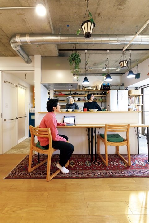 キッチンカウンターに座る長男とキッチンに立つ坂本さん親子