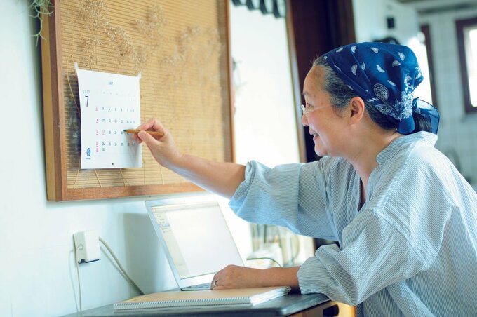 カレンダーに書き込む女性