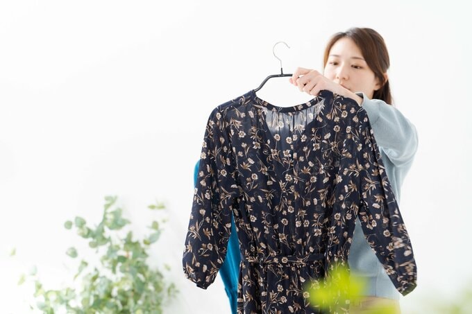 服を見つめる女性