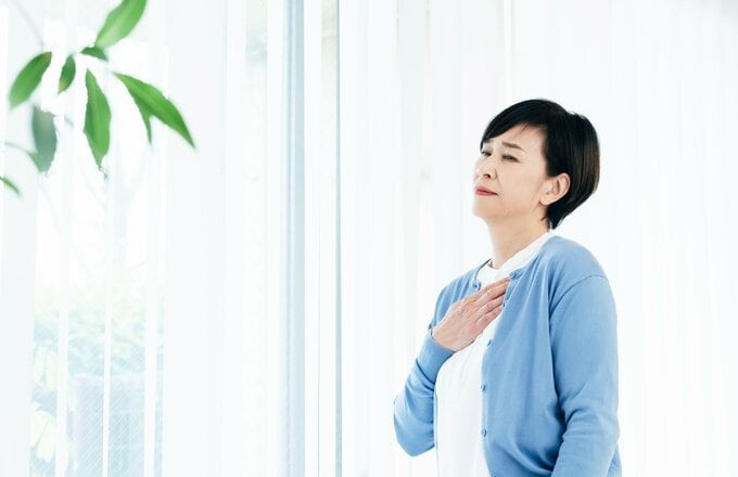 左胸を押さえる女性のイメージ画像