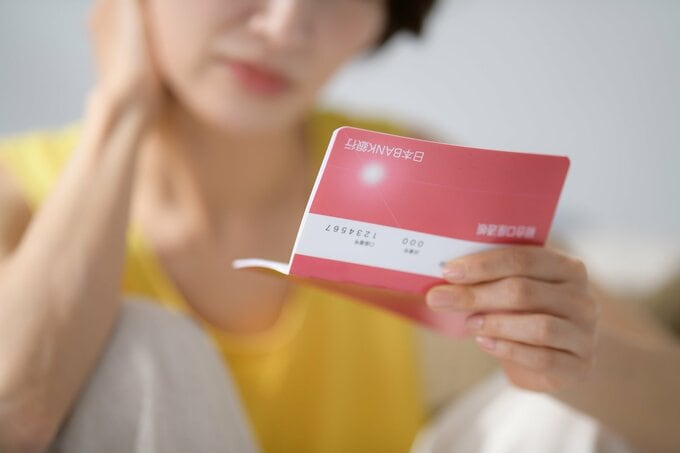 通帳を見る女性