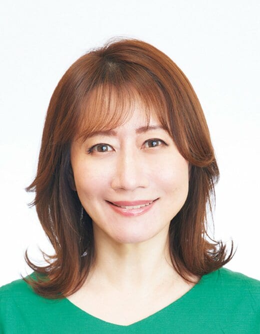 グリーンのトップスを着た笑顔の女性