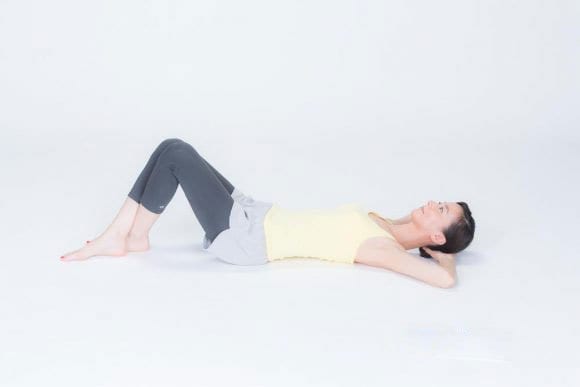 あお向けに寝て、ひざを立てて足首を交差させる