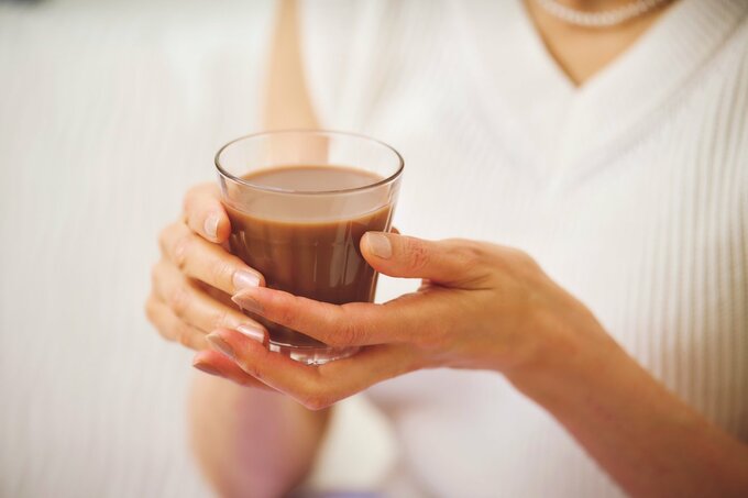 コップに入ったココアを両手で持っている様子