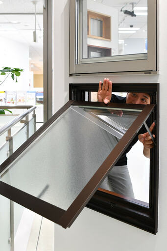 窓の隙間に少しだけ手を入れる様子