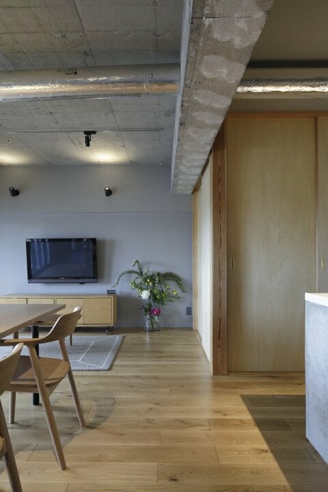 コンクリートの梁とダクトが大胆に交差する躯体現しのリビング