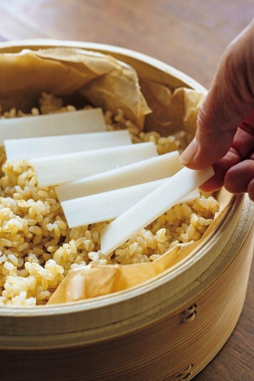 ご飯の上に切りもちをのせる様子