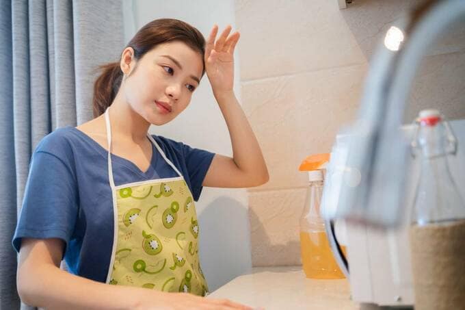 頭に手を置く女性