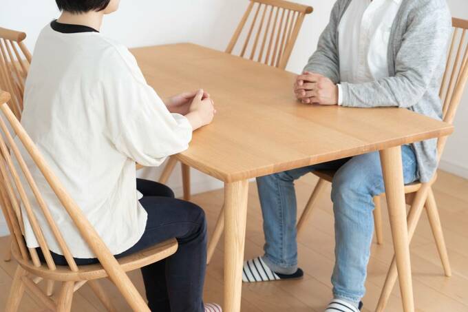 テーブルで向かい合わせに座る2人