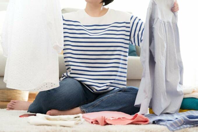 両手に服を持つ様子