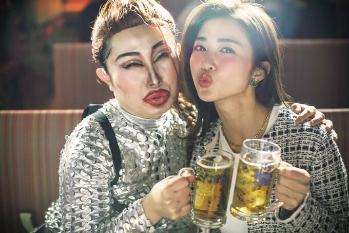 ビールのジョッキをもって頬を寄せる女性2人