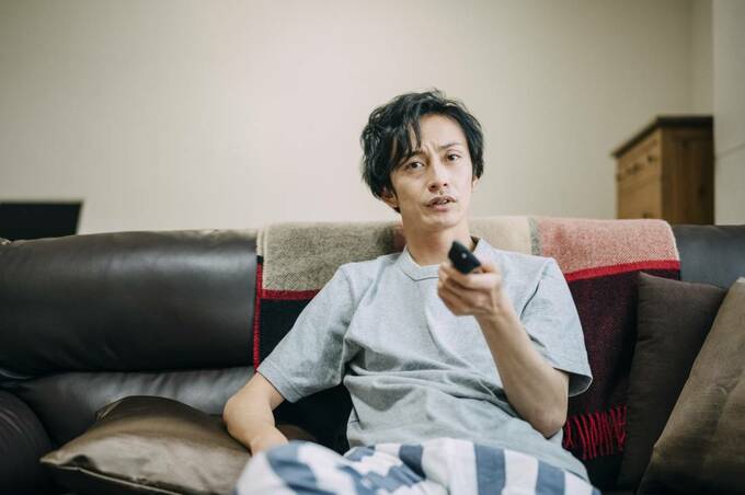 リモコンを持つ男性