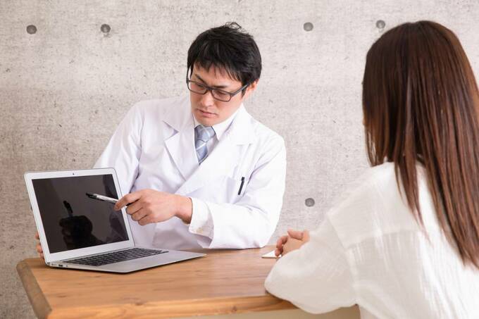 パソコンの画面を指す男性