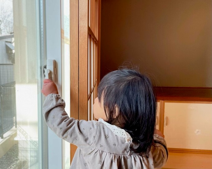 窓の鍵をあける子ども