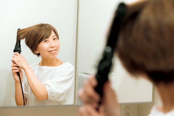 ヘアアイロンで髪を整える人