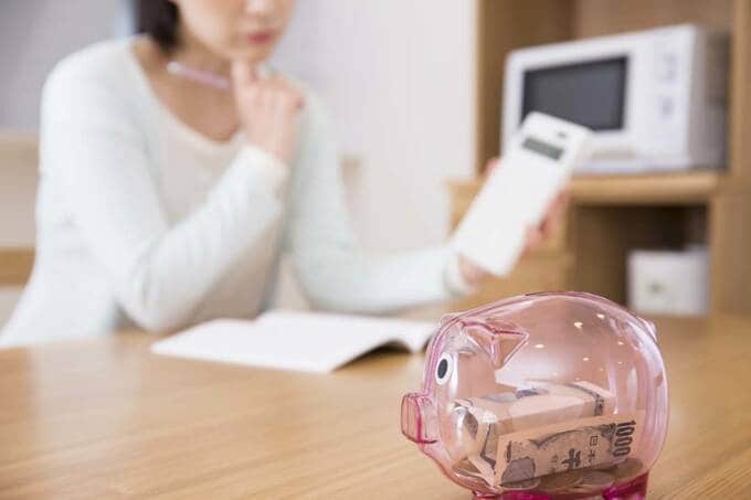 ブタの貯金箱と女性