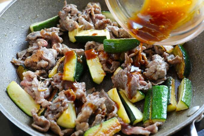 フライパンに調味料を入れる様子