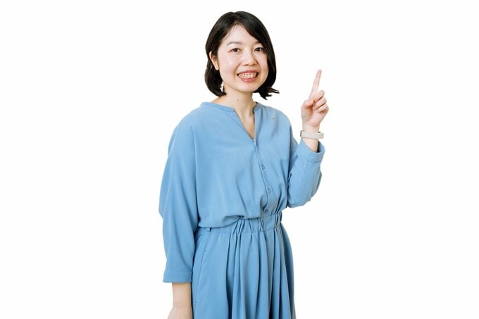 水色のワンピースを着た女性が人差し指を立てている様子