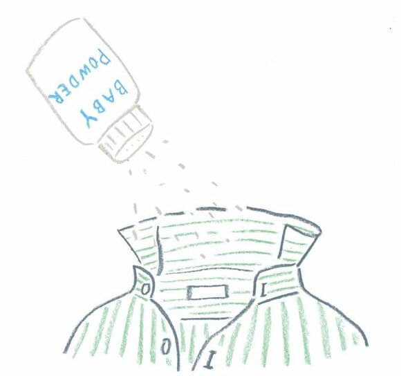 シャツの衿元にベビーパウダーをはたく