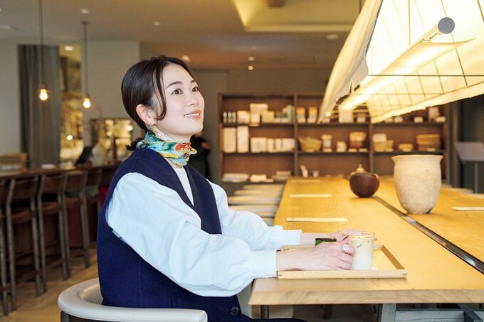 カフェのカウンター席に座りほほ笑む女性