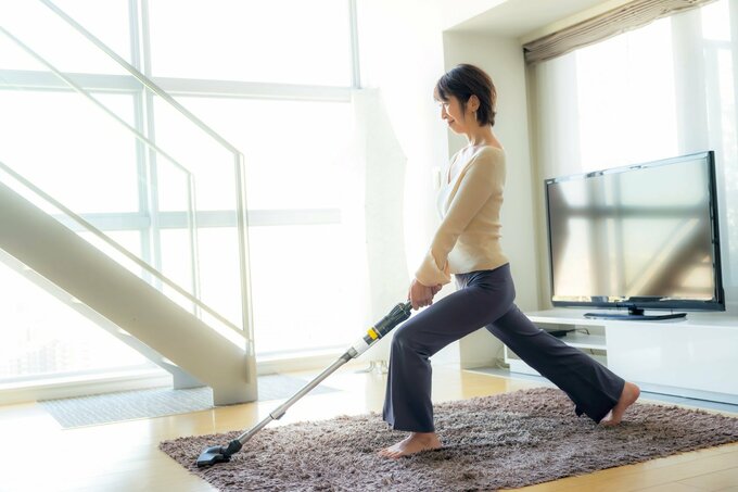 掃除機をかけながら運動する人
