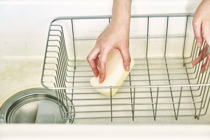 水きりカゴを洗う人