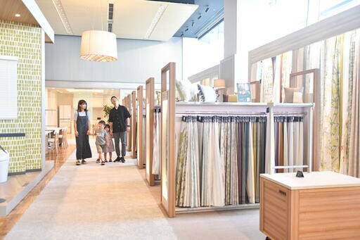カーテンの展示コーナーを歩く4人