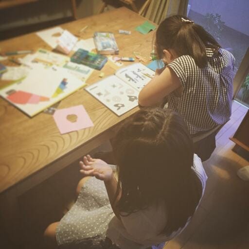 ダイニングテーブルで工作する姉妹