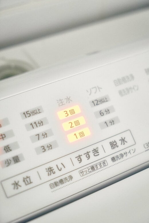 洗濯機のすすぎボタンが光っている様子
