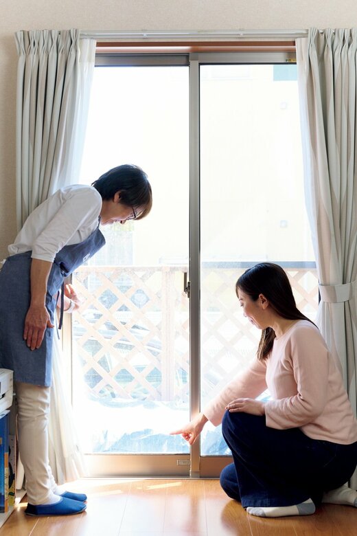 窓を見ながら話す女性とハウスキーパー