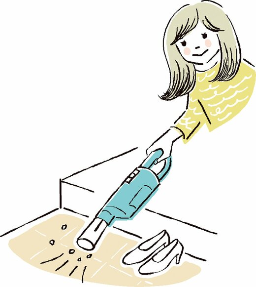 玄関掃除をする女性