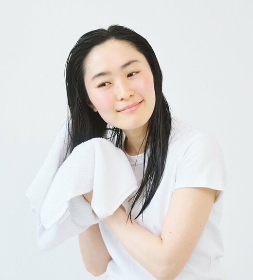 タオルで髪の水気をとる女性