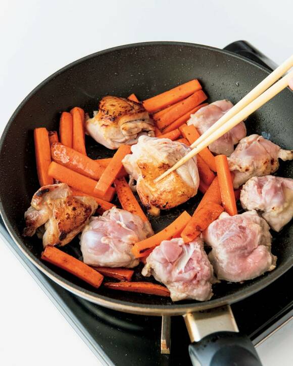 皮目を下にした鶏肉とニンジンを3~4分焼きつけ、裏返す